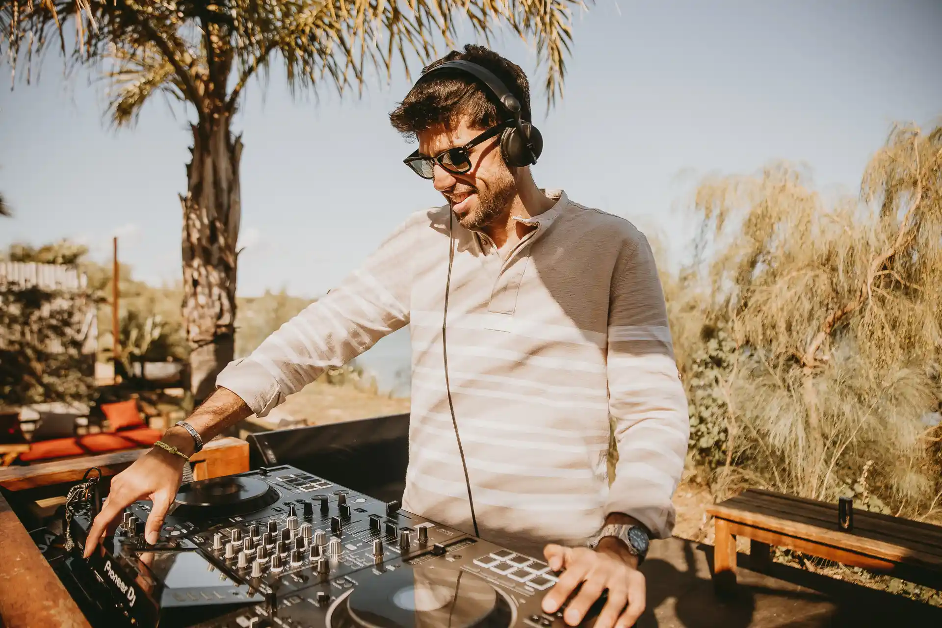 El DJ Ale Rodri pinchando música en directo con su mesa de mezclas en el beach club Playa Canalla, El Puerto de Santa María